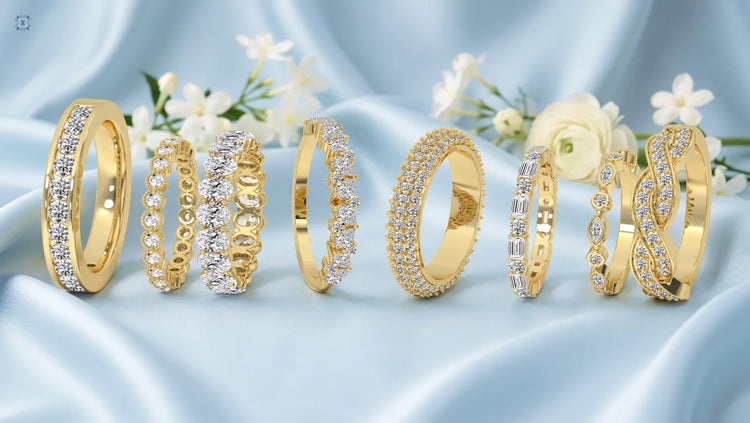 Luxury yellow gold diamond wedding rings arranged on silky blue fabric with floral accents
