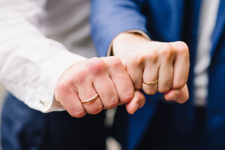 Two same sex person showing their wedding rings.