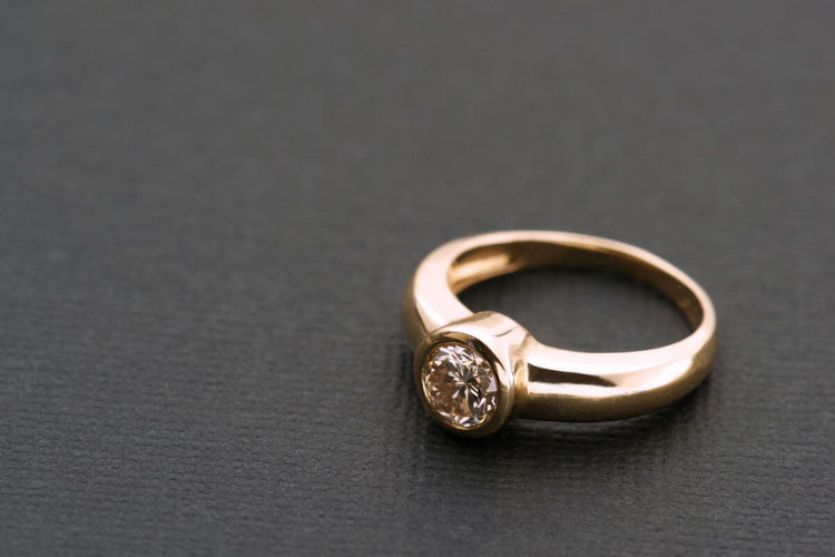 A gypsy setting ring kept on a smooth surface.