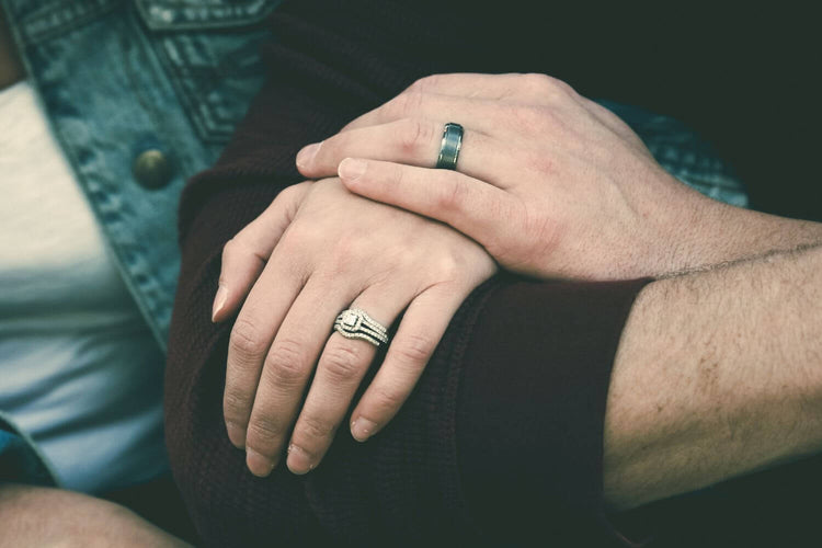 Two hands wearing promise rings