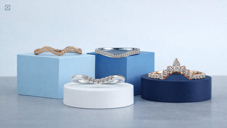 A variety of diamond-set curved wedding bands in rose, white, and yellow gold displayed on colorful geometric blocks.
