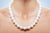 A woman wearing a high quality pearl necklace