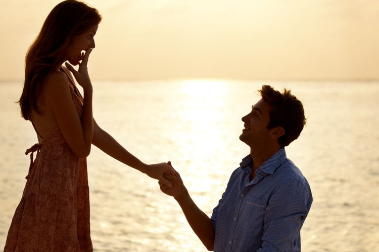 A guy proposing to his girlfriend at the beach without a ring.