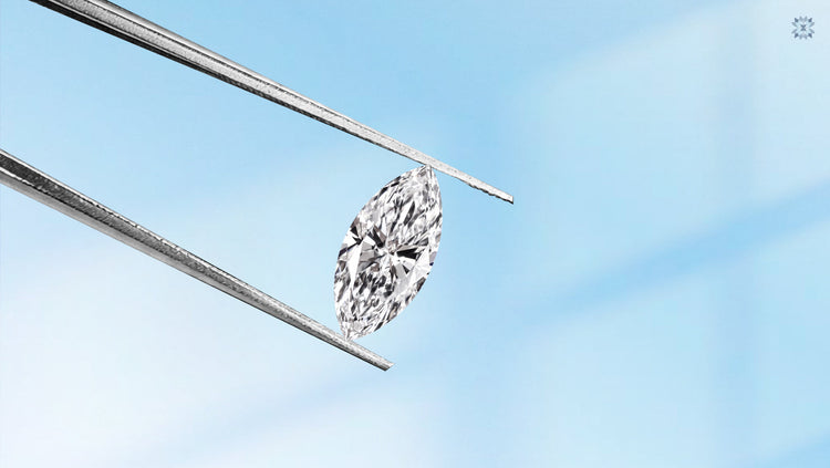 A sparkling marquise cut diamond held securely by metal jewelry tweezers against a soft blue gradient background.