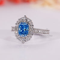 Double claw prong engagement ring with radiant cut blue diamond
