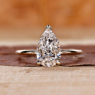 Pear-shaped engagement ring set in yellow gold with a secure prong setting.
