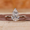 Pear-shaped engagement ring set in yellow gold with a secure prong setting.
