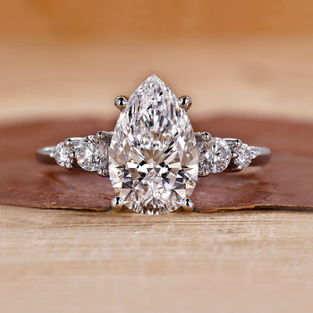 5 stone diamond ring with pear-cut center stone.
