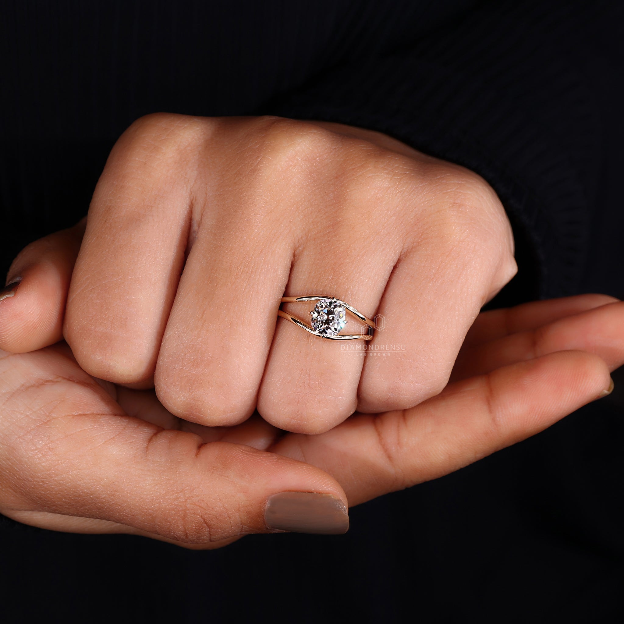 A model's hand adorned with a handmade cushion solitaire engagement ring, capturing its vintage charm.