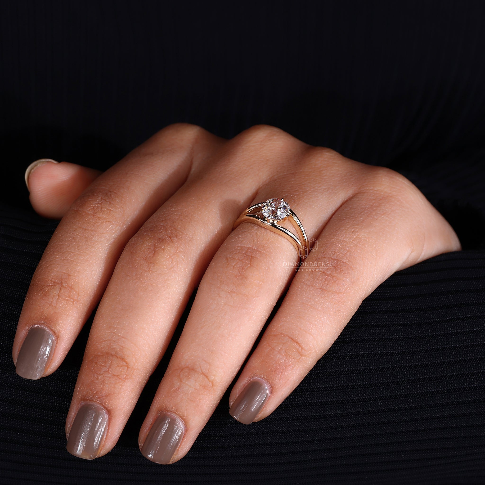 A woman showcasing a stunning old mine cut diamond ring with claw prongs on her finger.