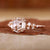 Hand wearing a vintage rose gold engagement ring, emphasizing its warm hue and romantic appeal