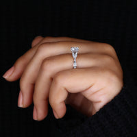 Round diamond engagement ring with claw prongs and split shank, embodying a nature-inspired theme.