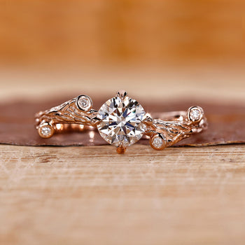 Nature-inspired engagement ring with intricate floral details and a stunning diamond center.

