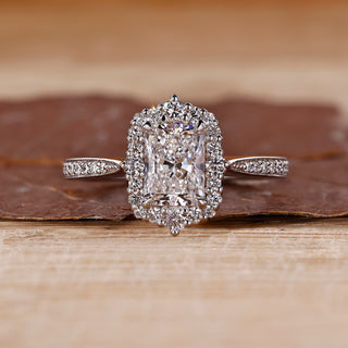 Radiant halo engagement ring with round cut diamond center stone.
