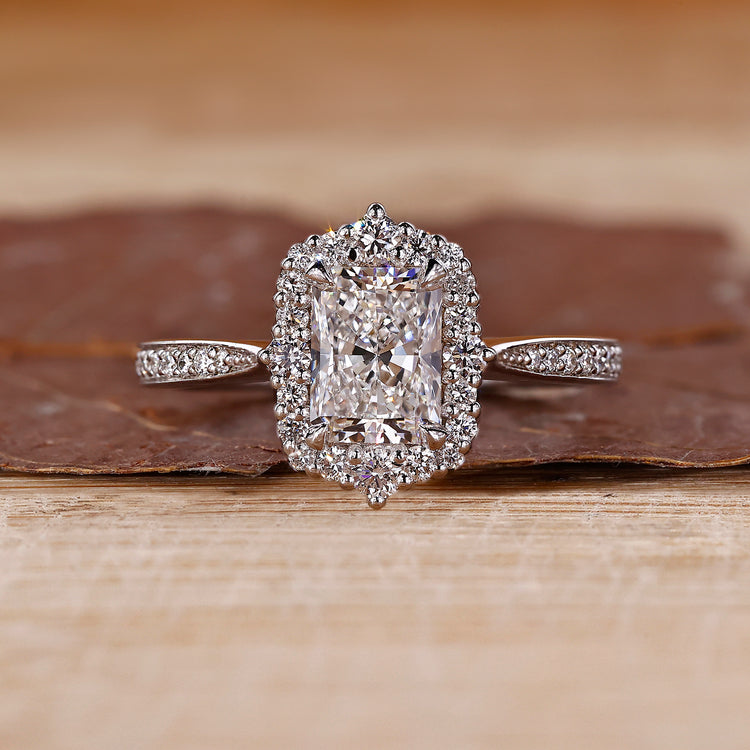 Radiant halo engagement ring with round cut diamond center stone.
