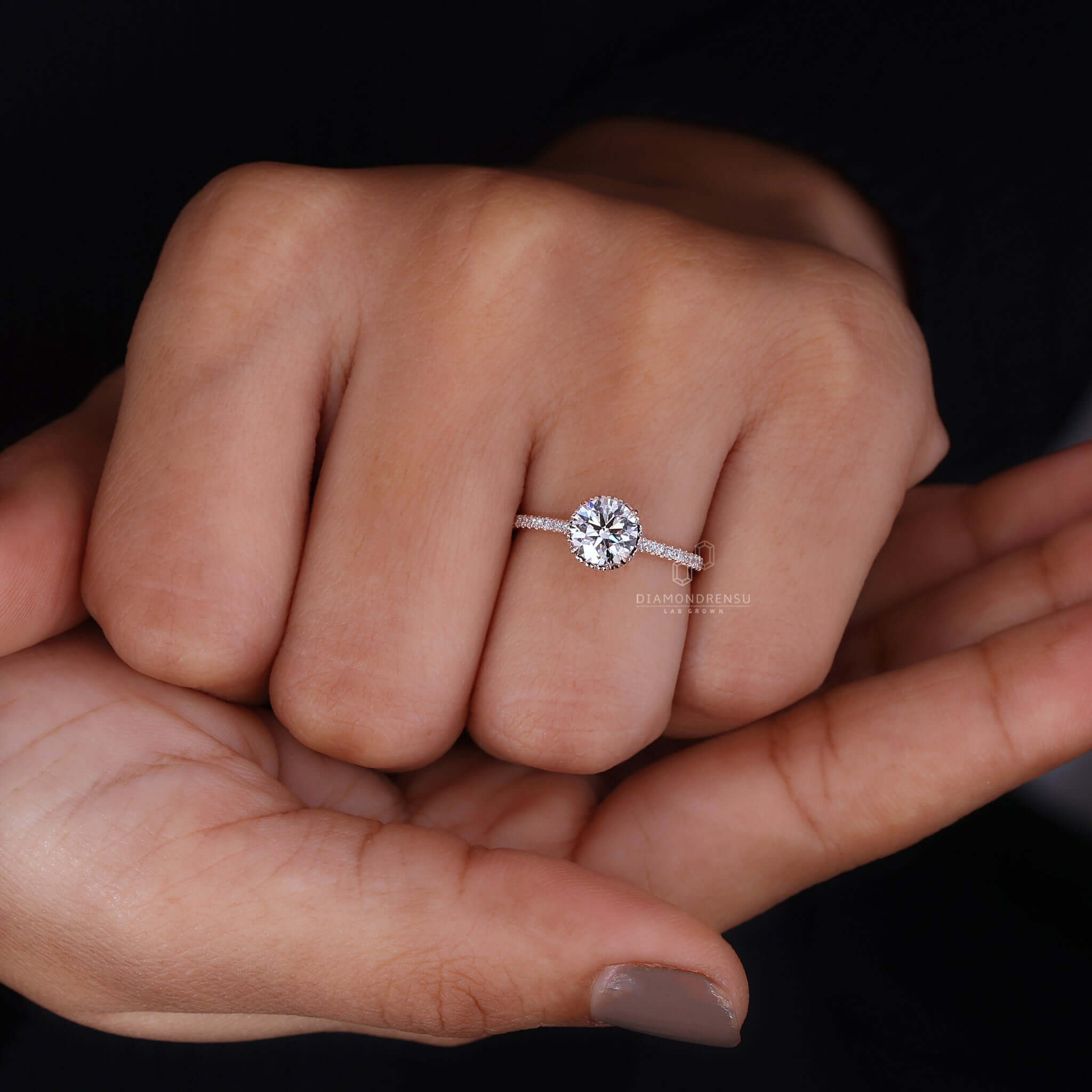 A hand model showcasing a Hidden Halo Engagement Ring for Women.