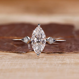 Marquise and round diamond ring in white gold with compass prong setting.
