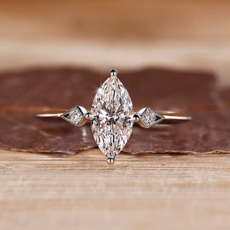 Marquise and round diamond ring in white gold with compass prong setting.
