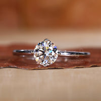 White gold ring with a round brilliant cut diamond at its center.

