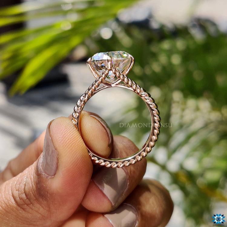 Six prong claw setting holding a brilliant moissanite.
