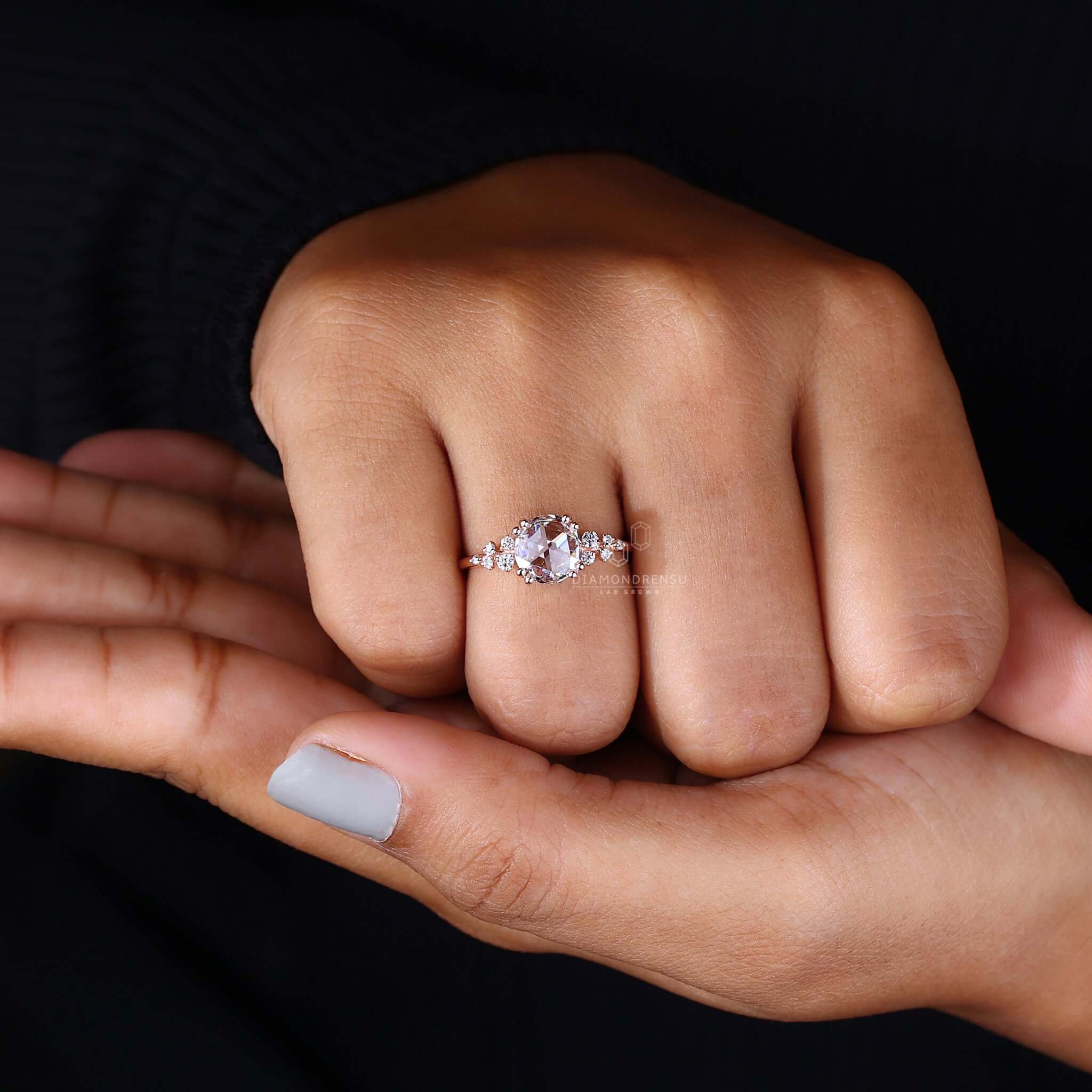 Hand delicately holding a rose cut diamond ring, highlighting its understated elegance and refined style.