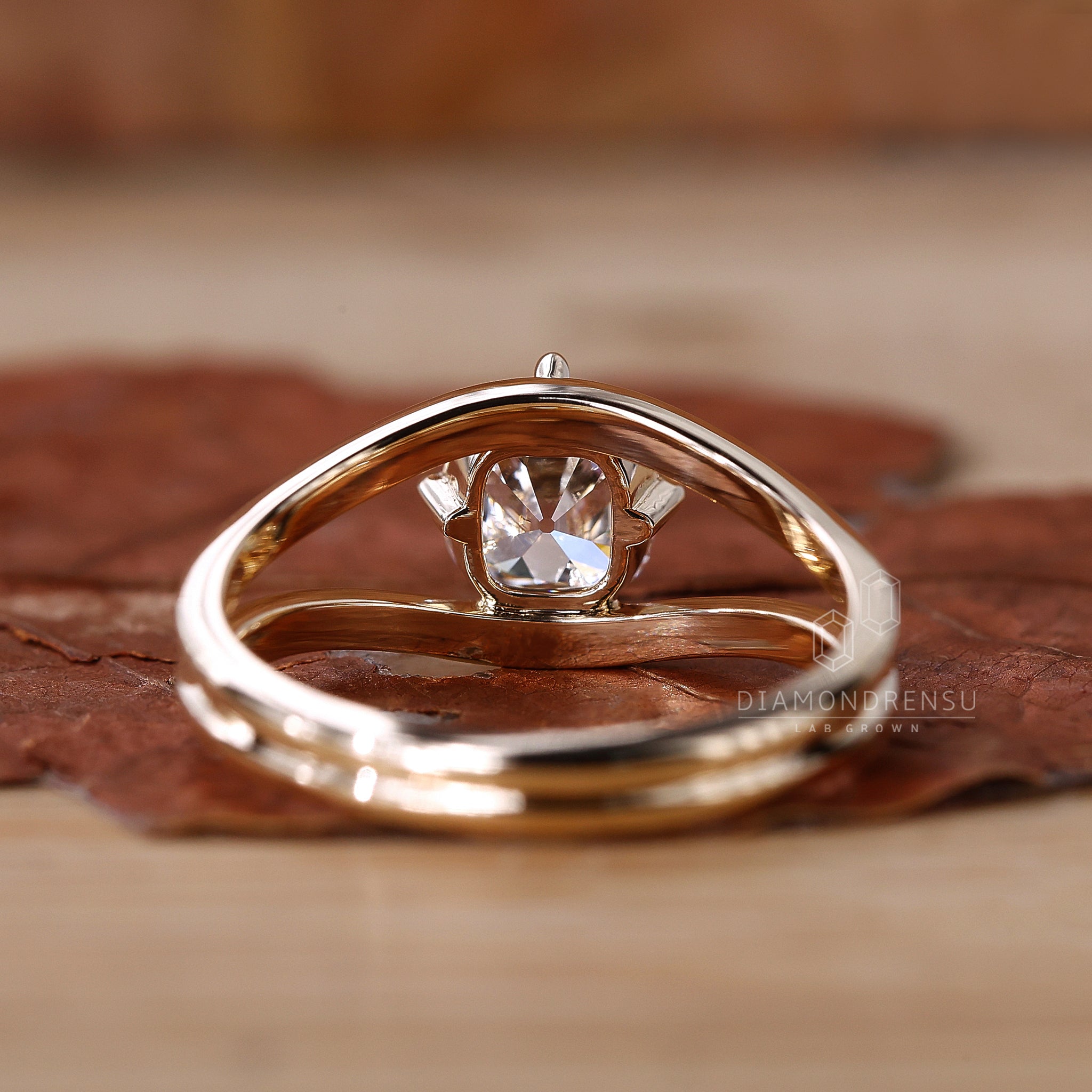 Close-up of a diamondrensu engagement ring featuring a cushion cut solitaire diamond.