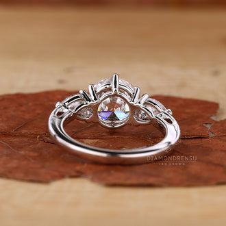 Three stone engagement ring with pear shaped side stones for added charm.
