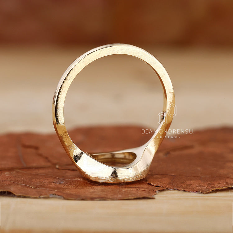 Unique round bezel engagement ring with sleek contours.
