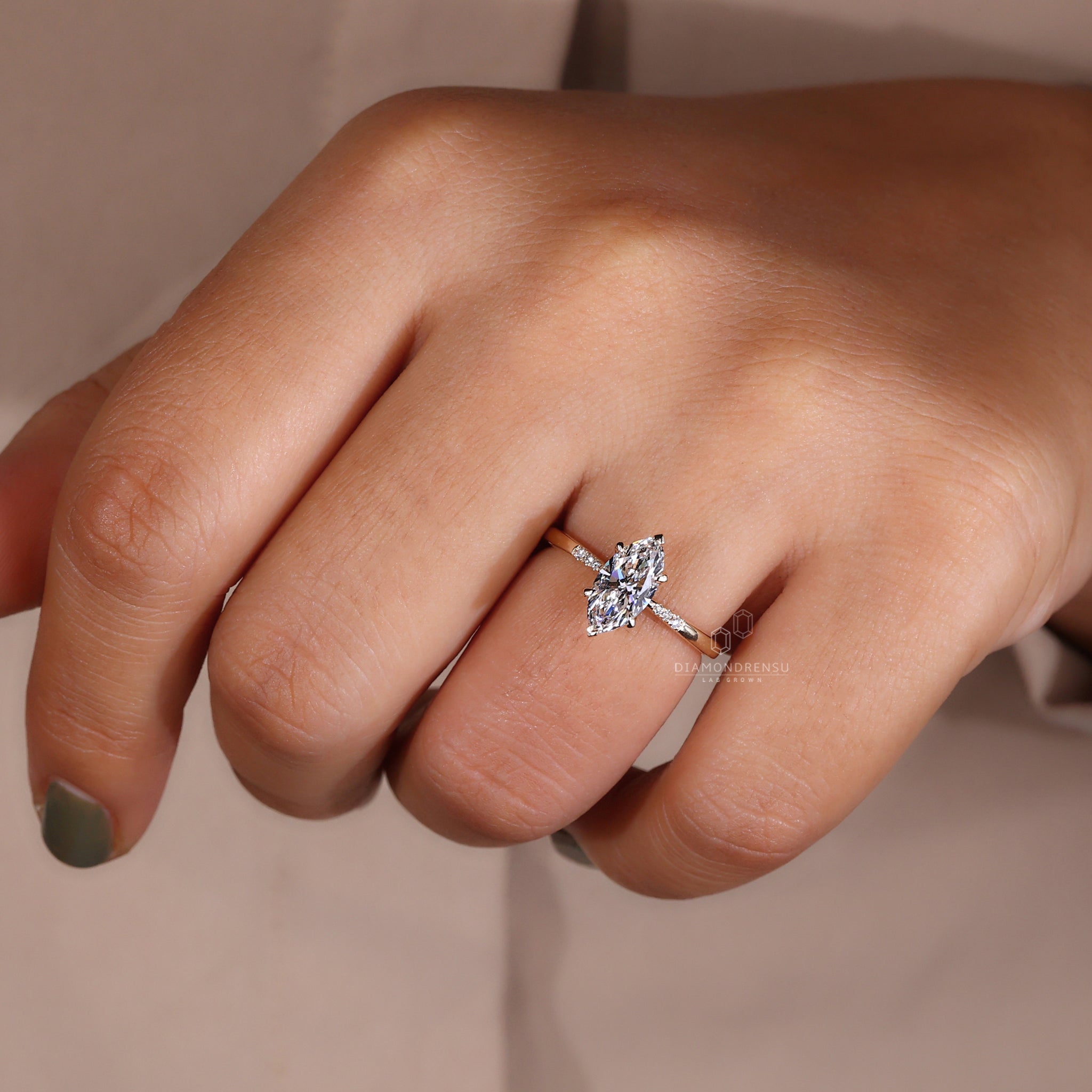 Model showcasing a beautiful marquise diamond engagement ring with a yellow gold band.