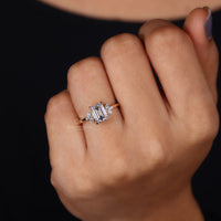 Emerald cut emerald ring with intricate prong setting for a secure fit.
