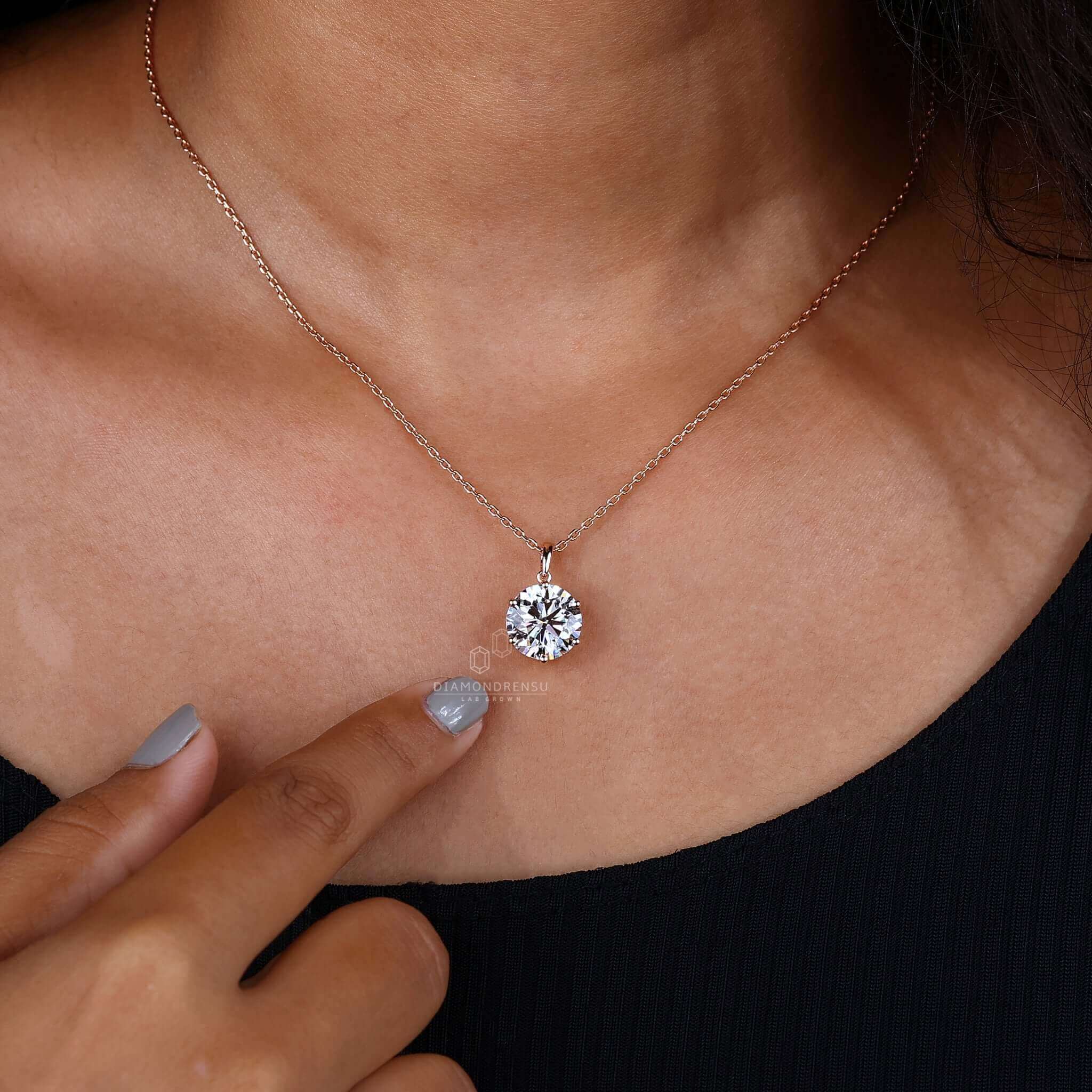 Close-up of a gold pendant with a round cut diamond in a basket setting.