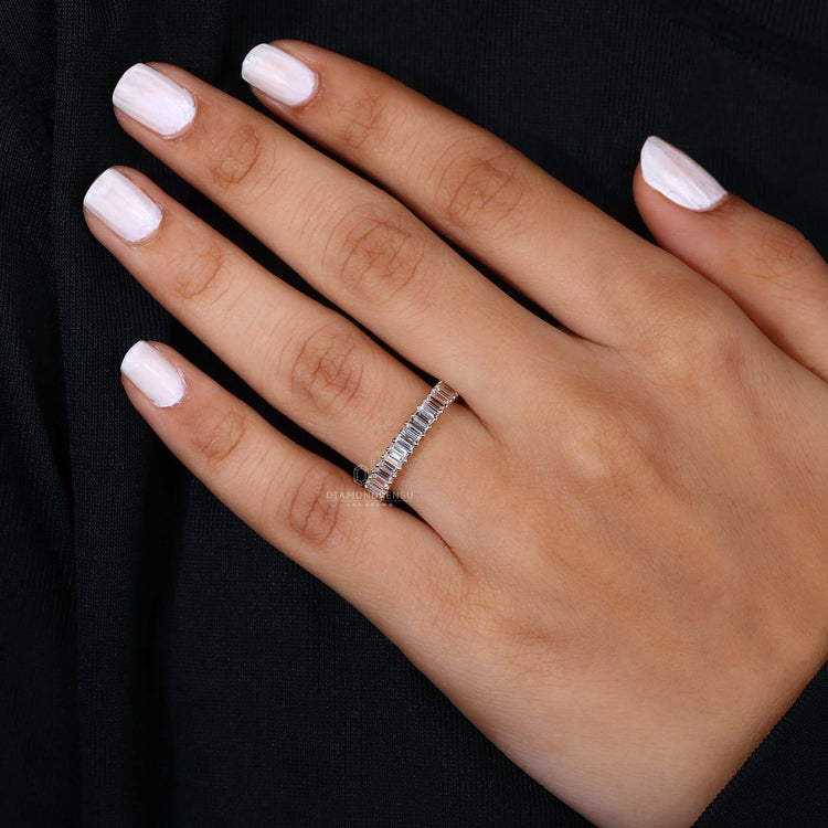Hand displaying the baguette diamond eternity band, emphasizing its elegant and modern design.