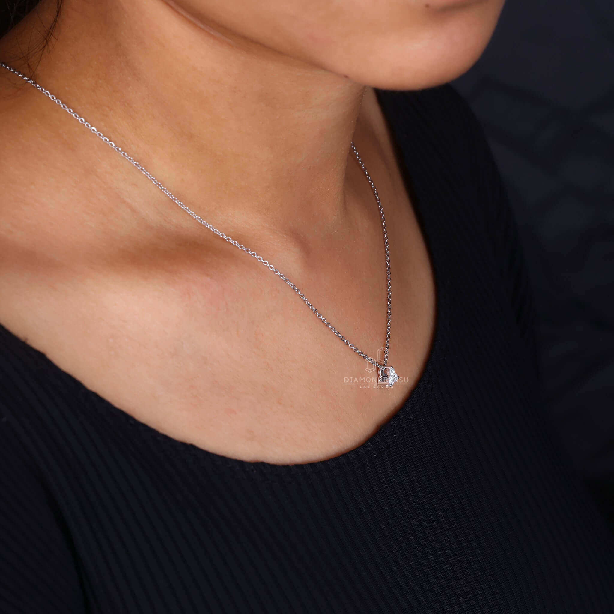 Close view on hand, featuring a diamond pendant for women, reflecting sophistication and style.