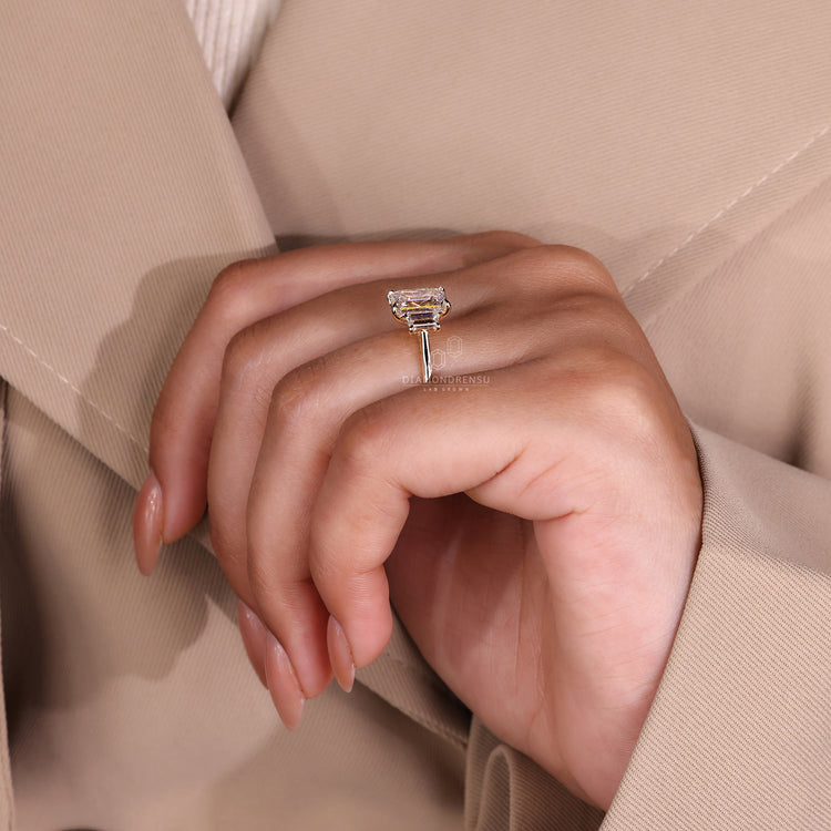 Emerald engagement ring featuring three stone diamonds for a classic touch.
