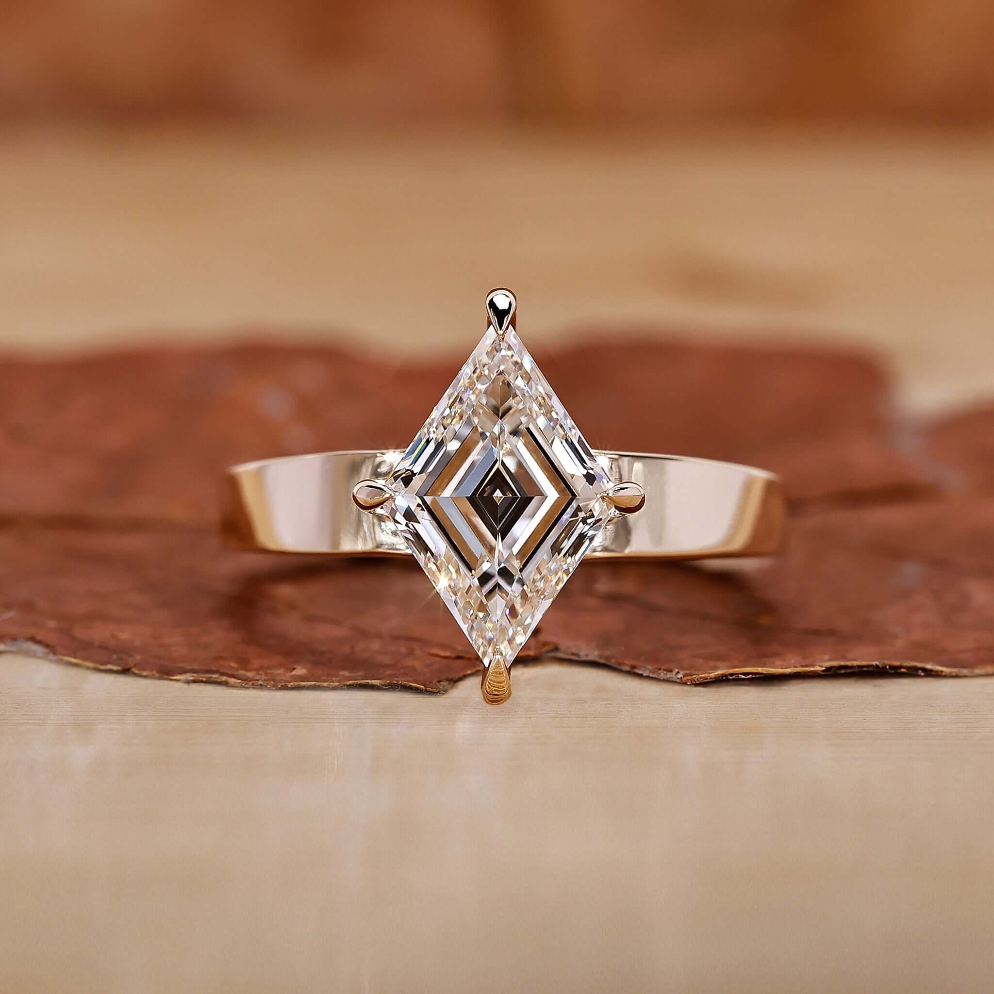 An elegant gold engagement ring featuring a stunning lozenge cut diamond as the centerpiece.