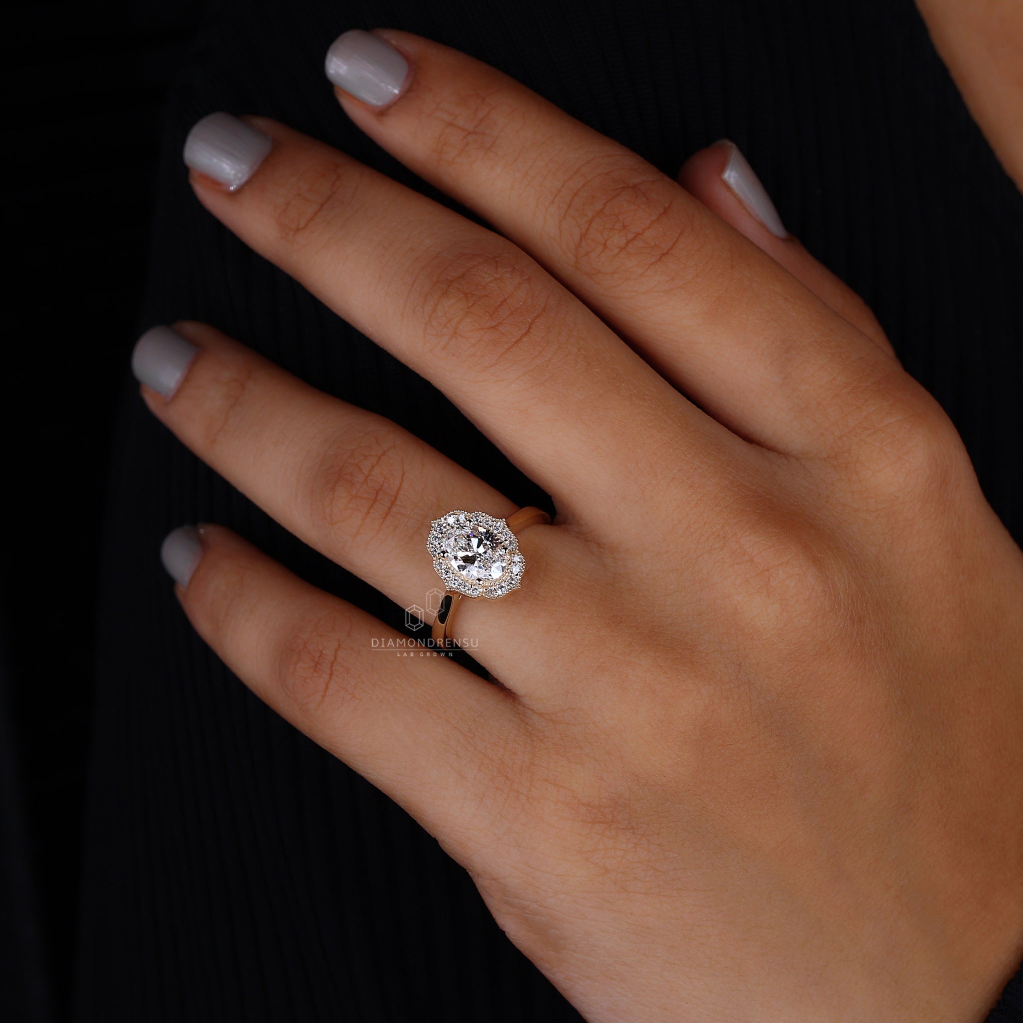 Close view of a model’s hand featuring an oval diamond ring, accentuating the stone's brilliance.