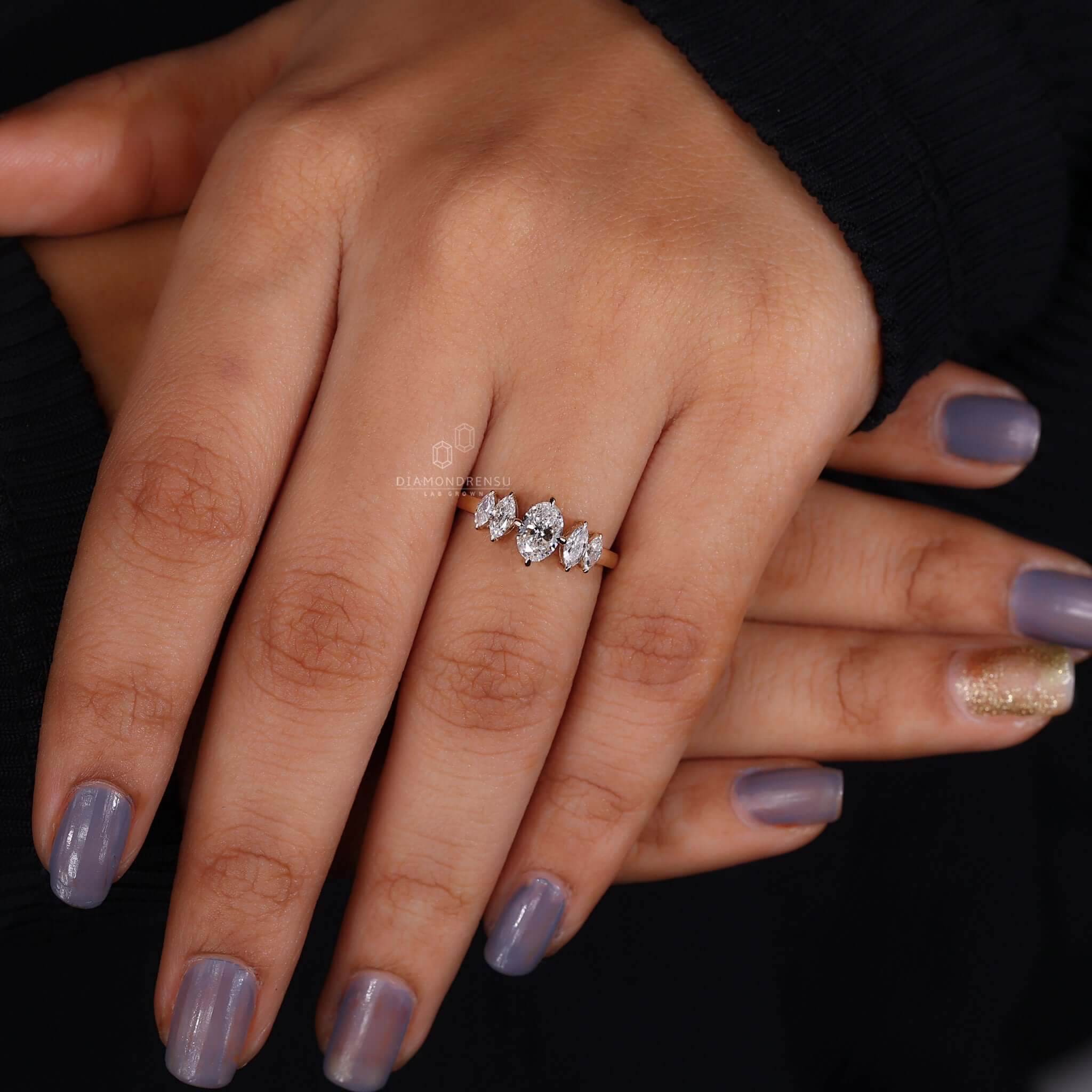 Hand model presenting a five stone engagement ring, highlighting its symbolic significance and charm.