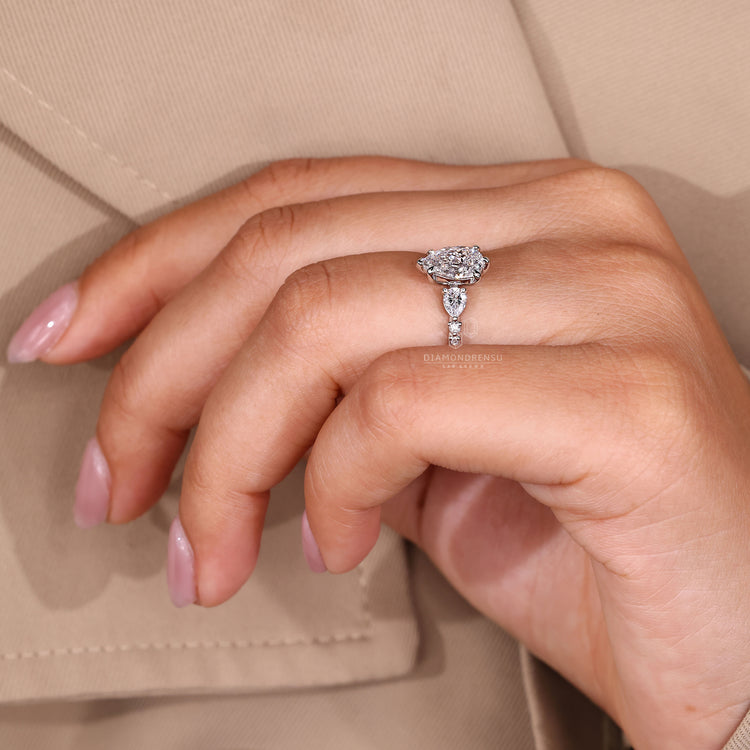 White gold diamond ring with pear shaped center stone.
