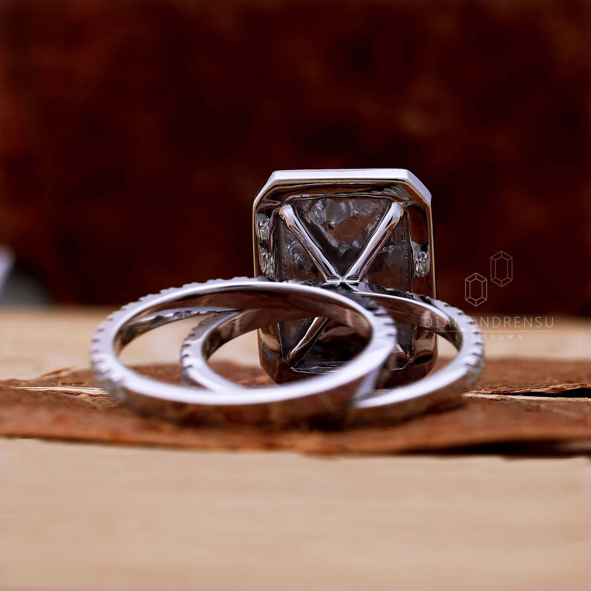 A lifestyle image of a beautifully decorated table setting with a velvet jewelry box containing a diamond engagement ring with a cluster setting in the center.