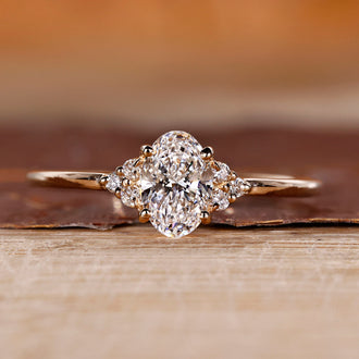 Oval diamond engagement ring in yellow gold with muse setting design.
