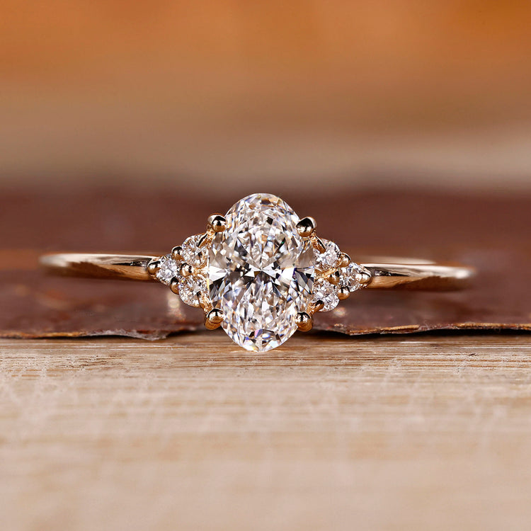 Oval diamond engagement ring in yellow gold with muse setting design.
