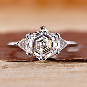 Hexagon diamond engagement ring with bezel setting in white gold.
