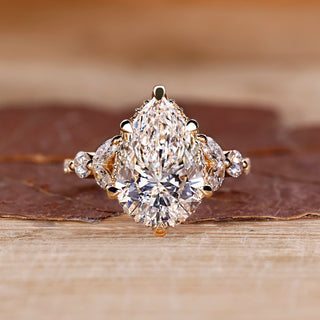 Pear cut diamond ring with hidden halo and marquise side stones.
