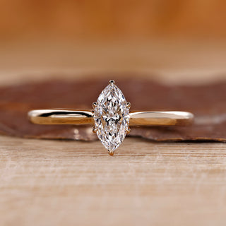 Marquise solitaire diamond ring with a yellow gold band.
