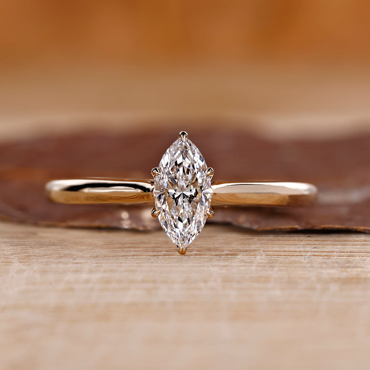 Marquise solitaire diamond ring with a yellow gold band.
