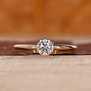 Diamondrensu engagement ring crafted with round diamond solitaire and gold prongs.
