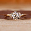 Hexagon step cut center diamond ring in yellow gold.
