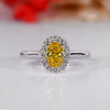 Oval cluster halo ring with canary yellow oval diamond center.
