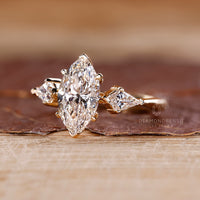 Yellow gold ring with marquise diamond and three stone arrangement.

