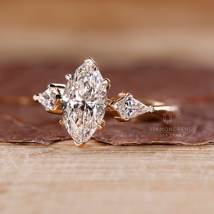 Yellow gold ring with marquise diamond and three stone arrangement.
